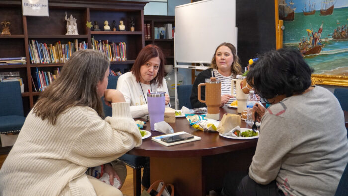 Group of office managers sitting at tables eating