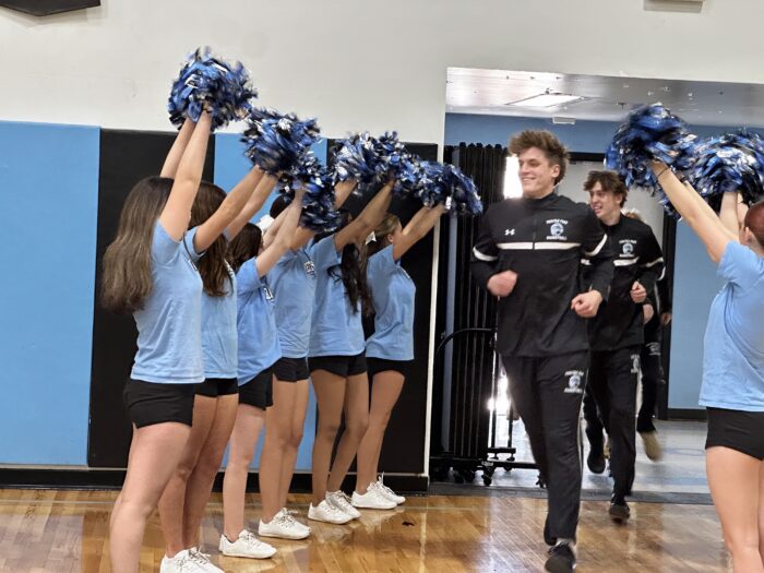 Spirit line cheering on basketball players as they enter the gym