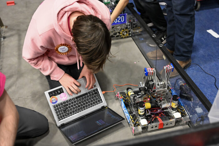 Student working on a robot with a laptop