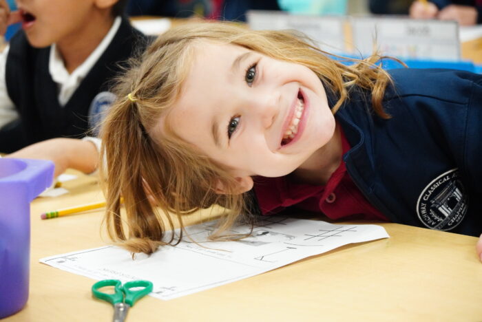 Young girl smiling at desk