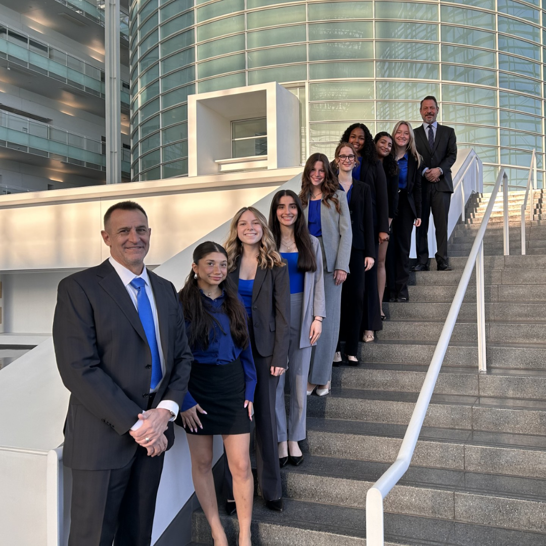 Veritas Prep Mock Trial team and coaches posing on an exterior staircase