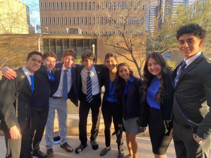 Group of students in business attire posing outdoors