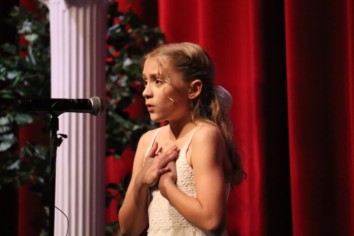 Student at a microphone on stage.