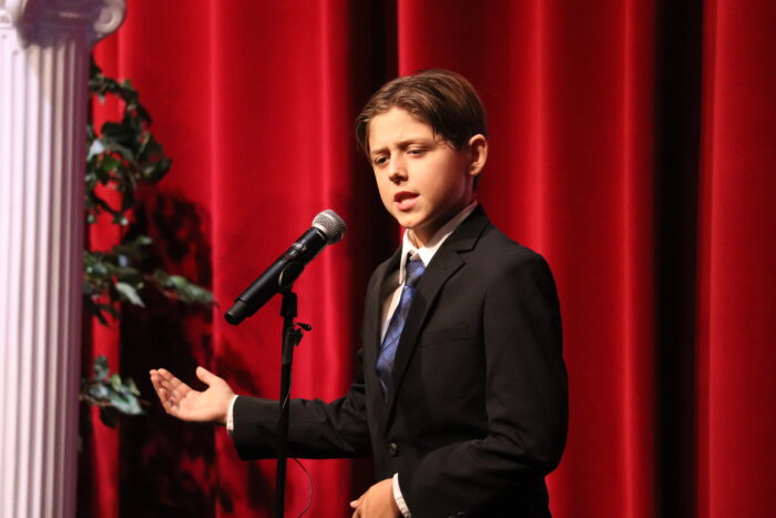 Student at a microphone on stage.