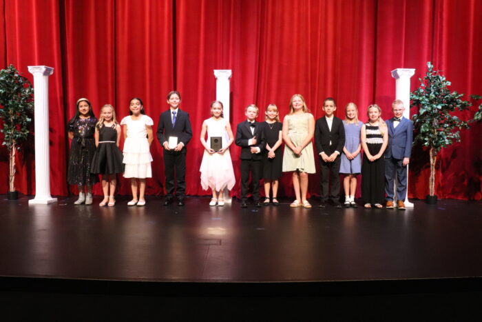 Group of 12 students on a stage.