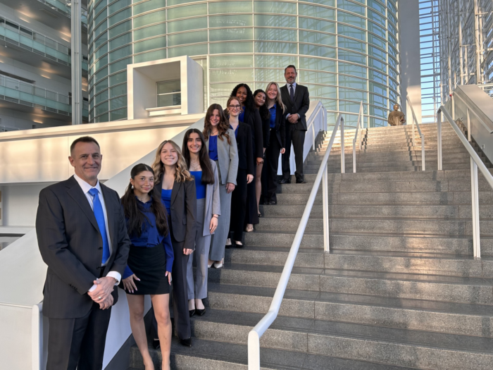 Veritas Prep Mock Trial team and coaches posing on an exterior staircase