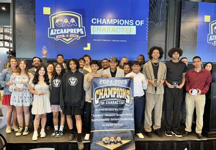 Award Winners and Parents posing on a stage.