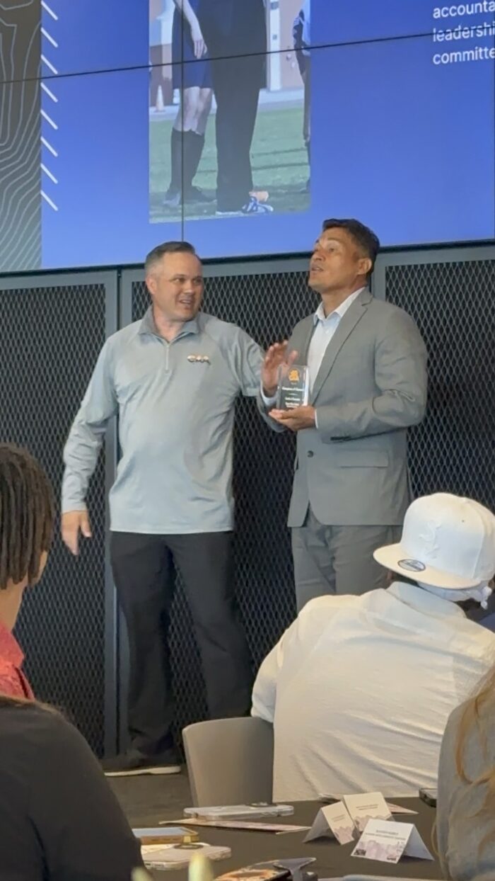 Coach receiving an award