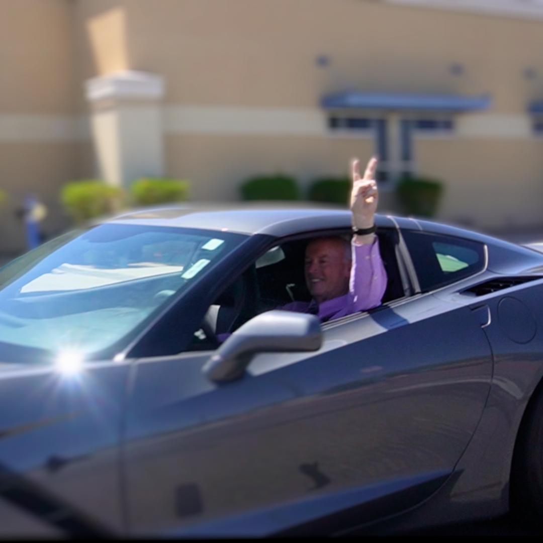 Mr. Tierney in his Corvette waving