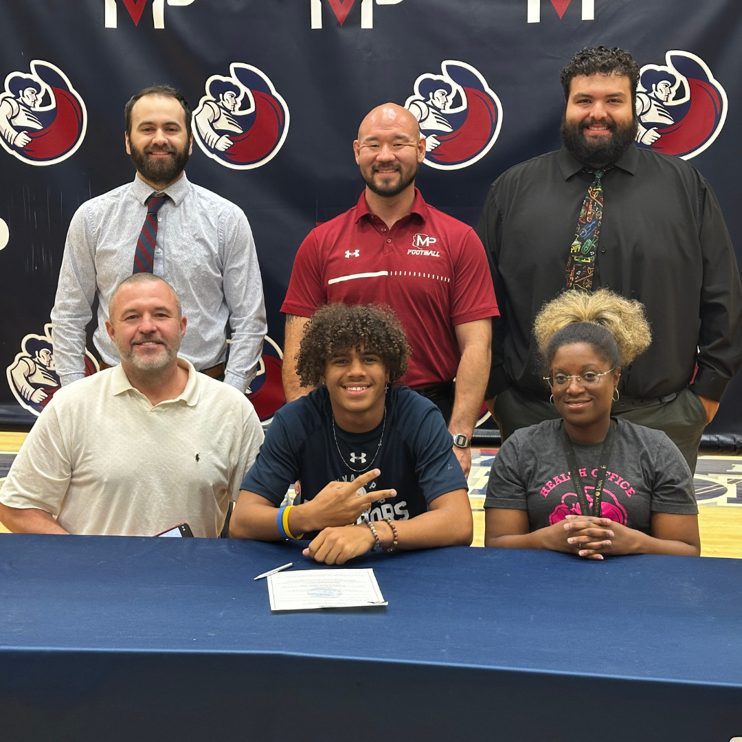 Senior posing with parents and coaches at table
