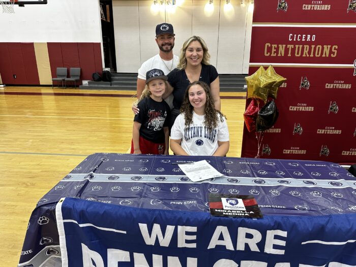 Student-athlete going to Penn State posing with her family