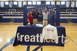 Student athlete posing with his family and Yale apparel