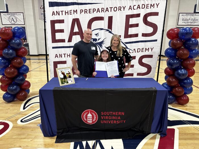 Student with family behind a table with Southern Virginia University logo