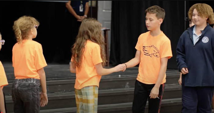 Students receiving pins from 5th graders