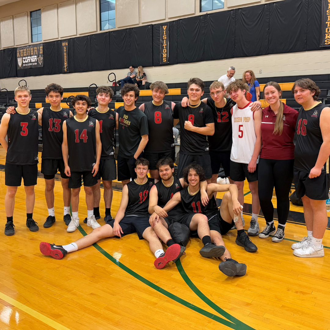 Cicero boys volleyball team posing together in front of bleachers