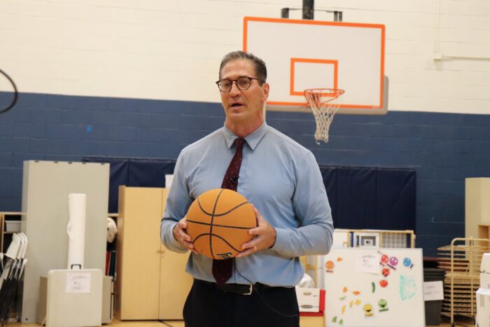 Dan Scoggin holding a basketball in a gym