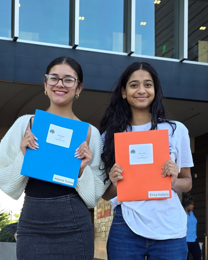 Two students posing in front of city hall