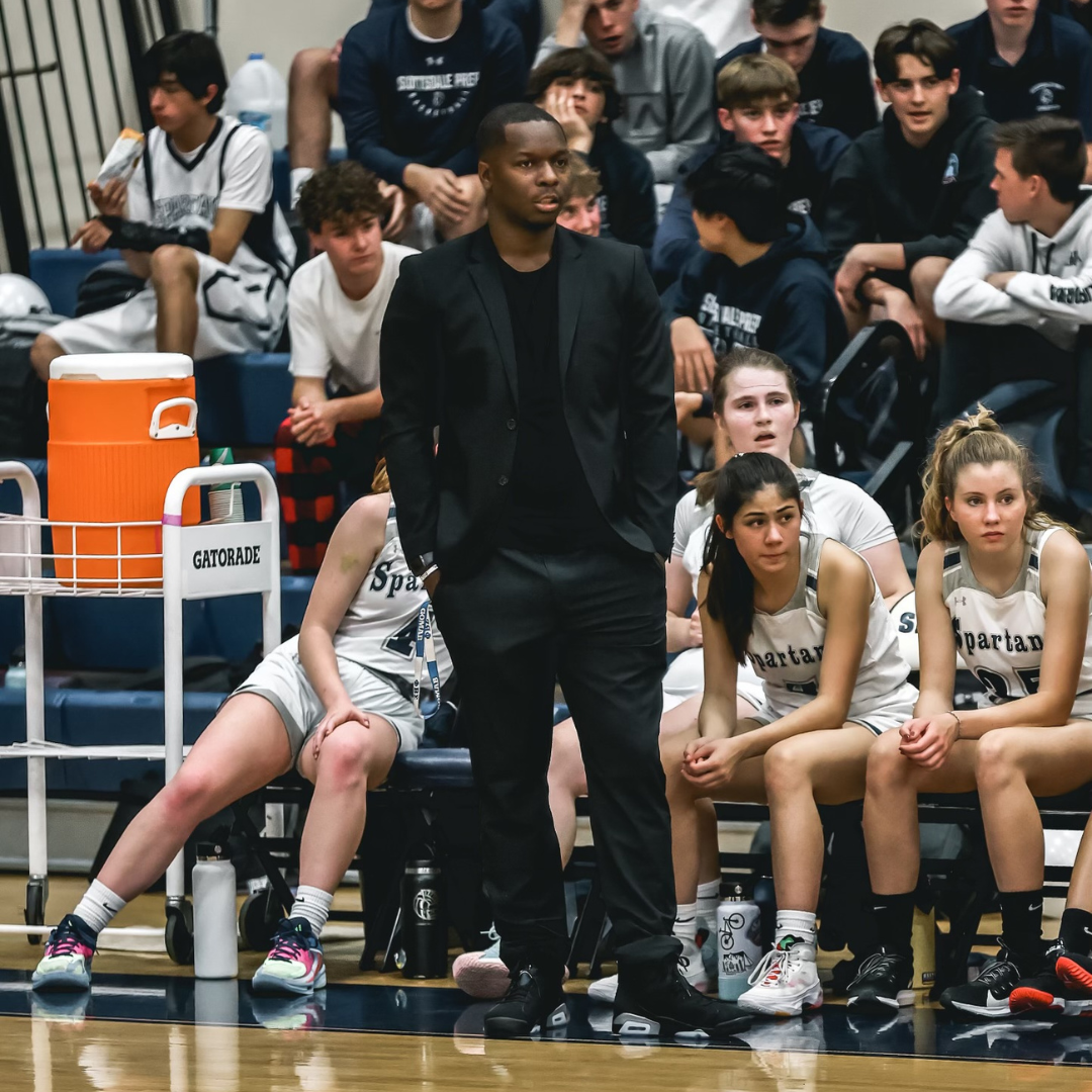 Coach standing on the side of a basketball court