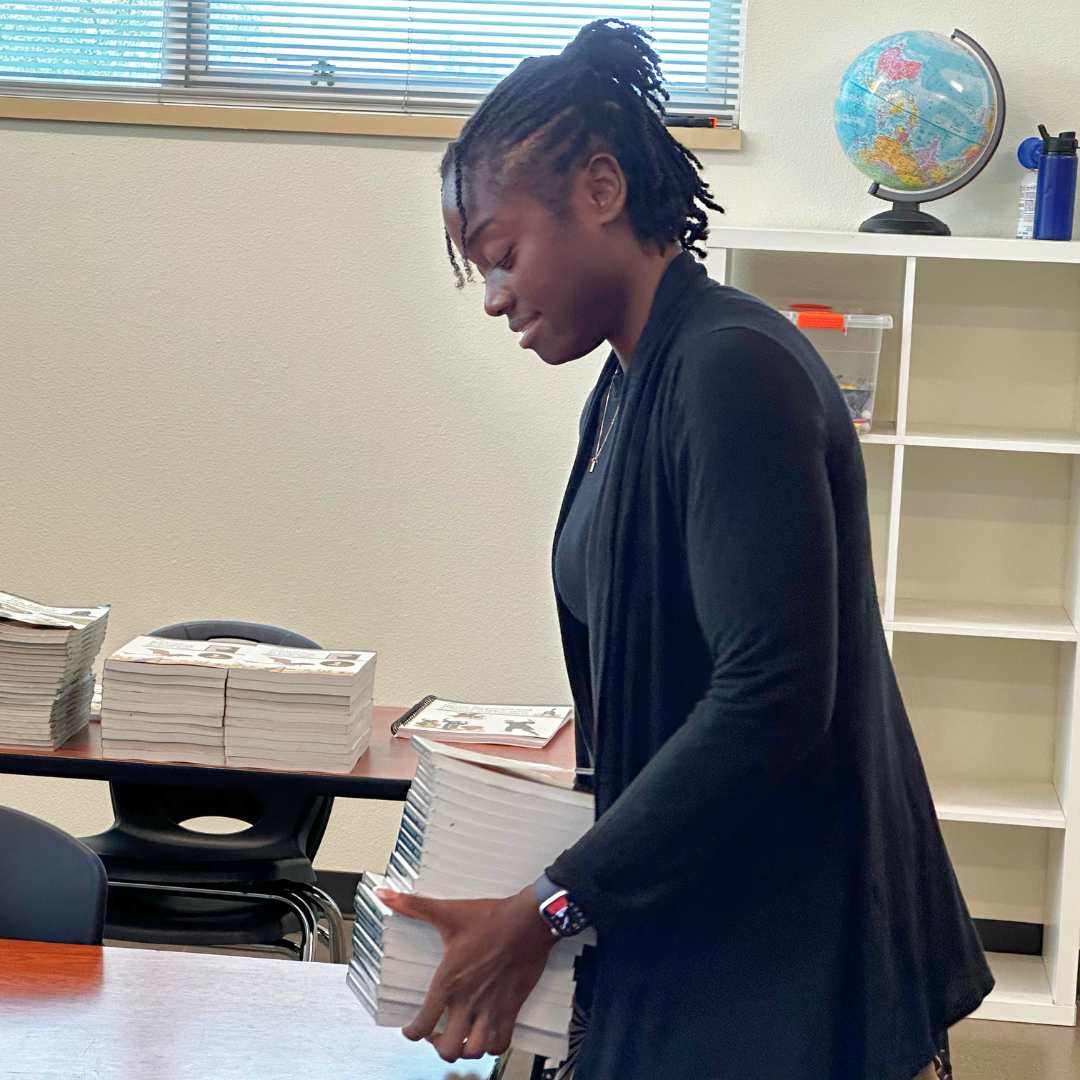 Teacher setting out books