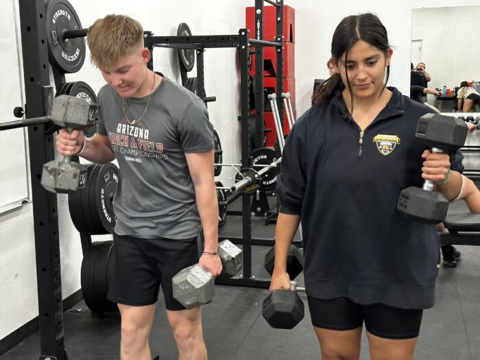 Two students lifting weights