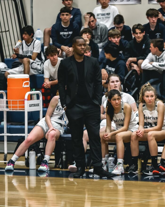 Coach standing on the side of a basketball court