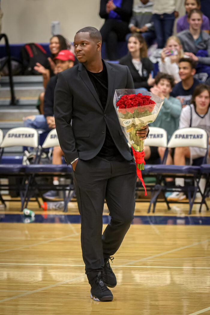 Coach on basketball court with a bouquet of roses