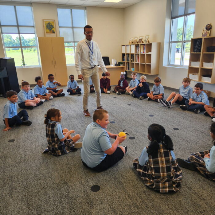 Teacher in the middle of a circle of young students