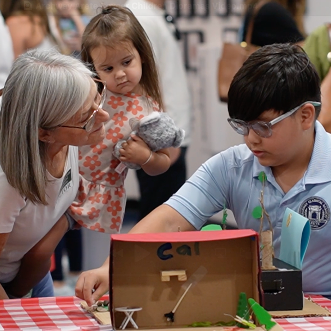 Student showing diorama to a parent