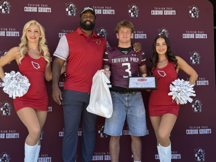 Trivium Prep Player with cheerleaders and Zach Moore