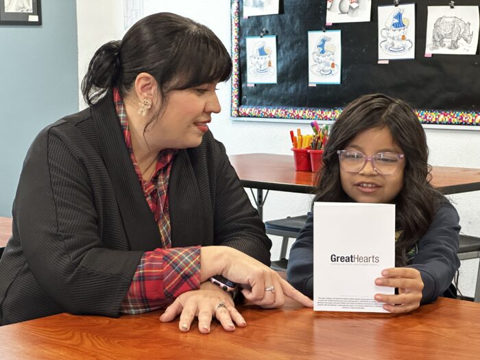 Girl showing artwork to Headmaster
