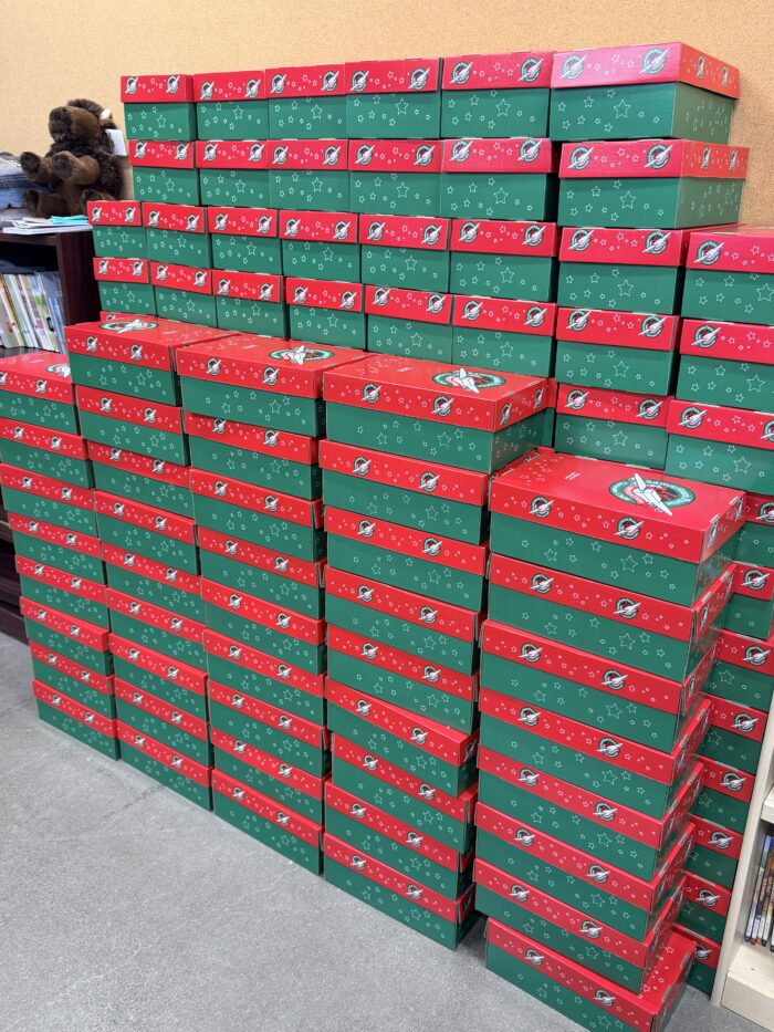 stack of shoe boxes filled with donations at great hearts christian academies
