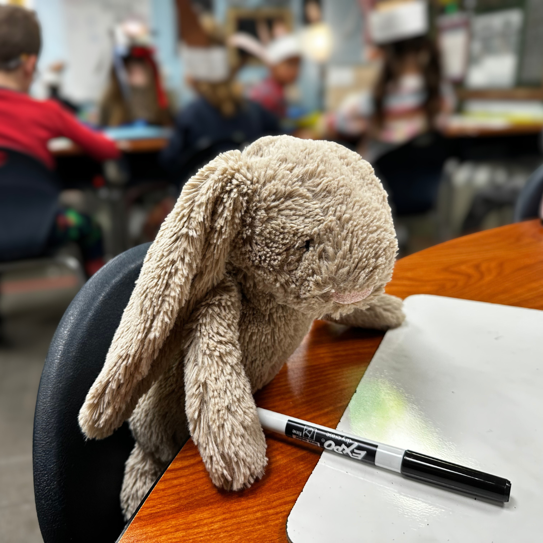 Toy rabbit sitting at desk