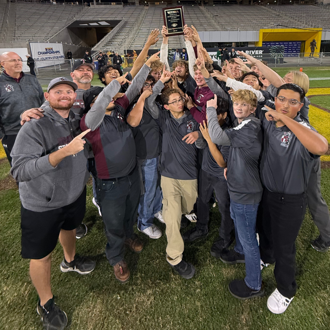Trivium Prep football players and coaches holding an award on a football field