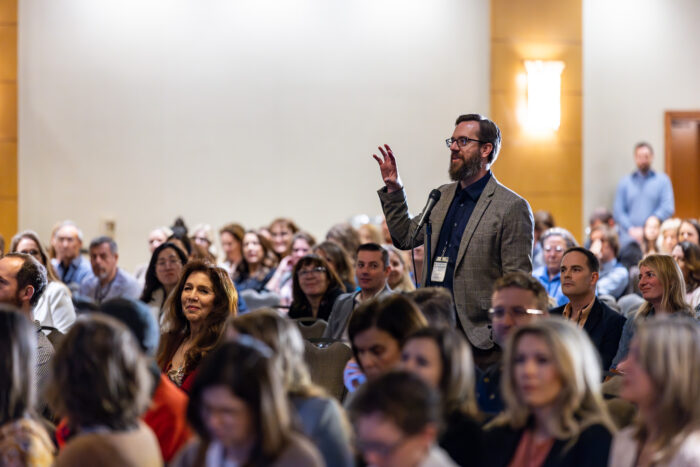 Man asking question from audience at Symposium