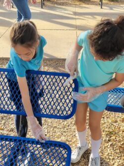 Students cleaning a bench