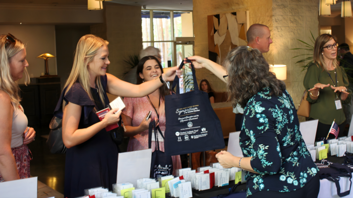 People checking in at Symposium