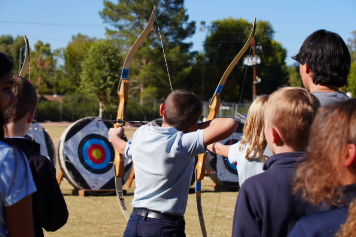 Student doing archery at Robin Hood Day