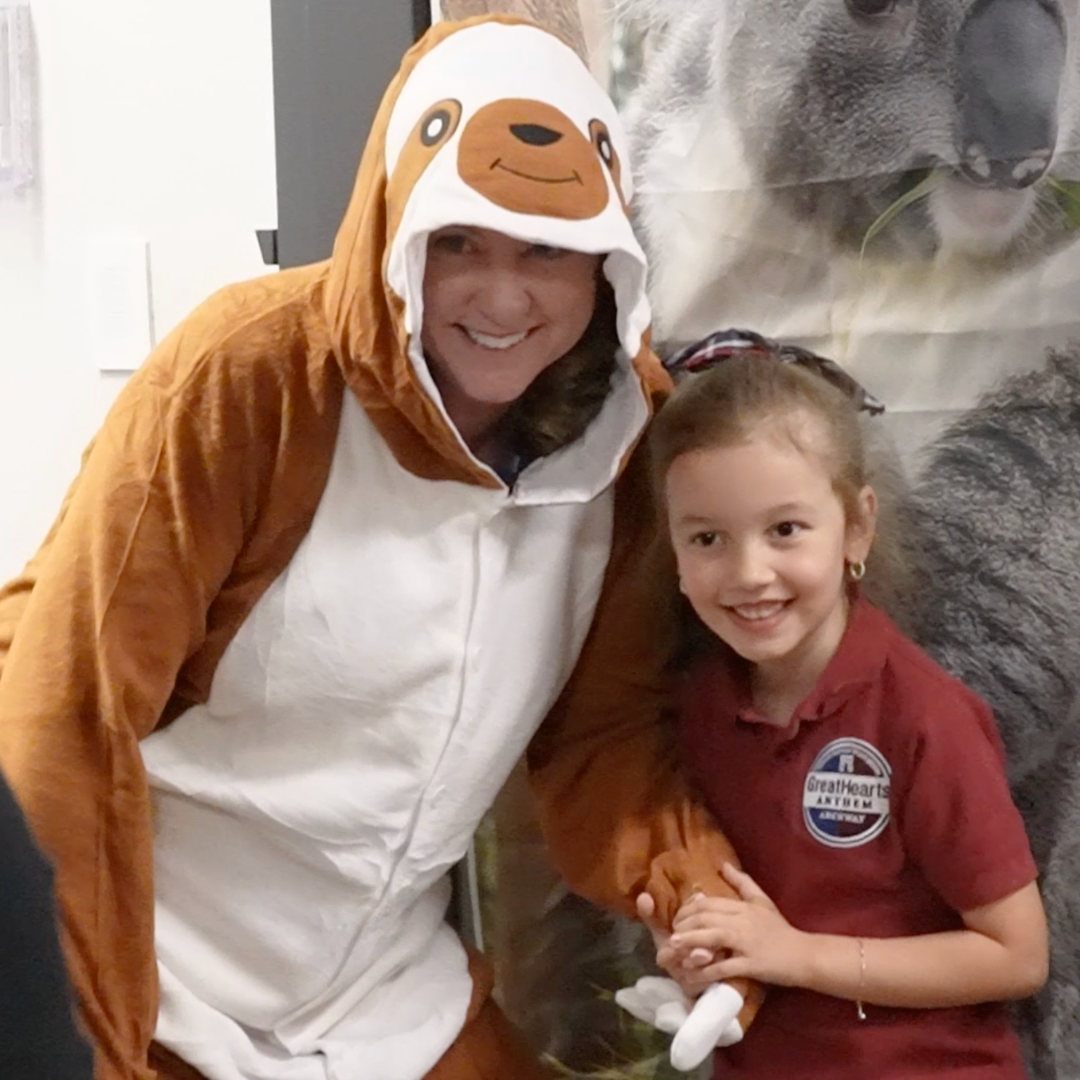 Teacher dressed like sloth posing with a student