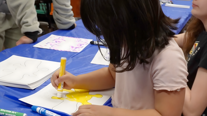 Young girl coloring with markers