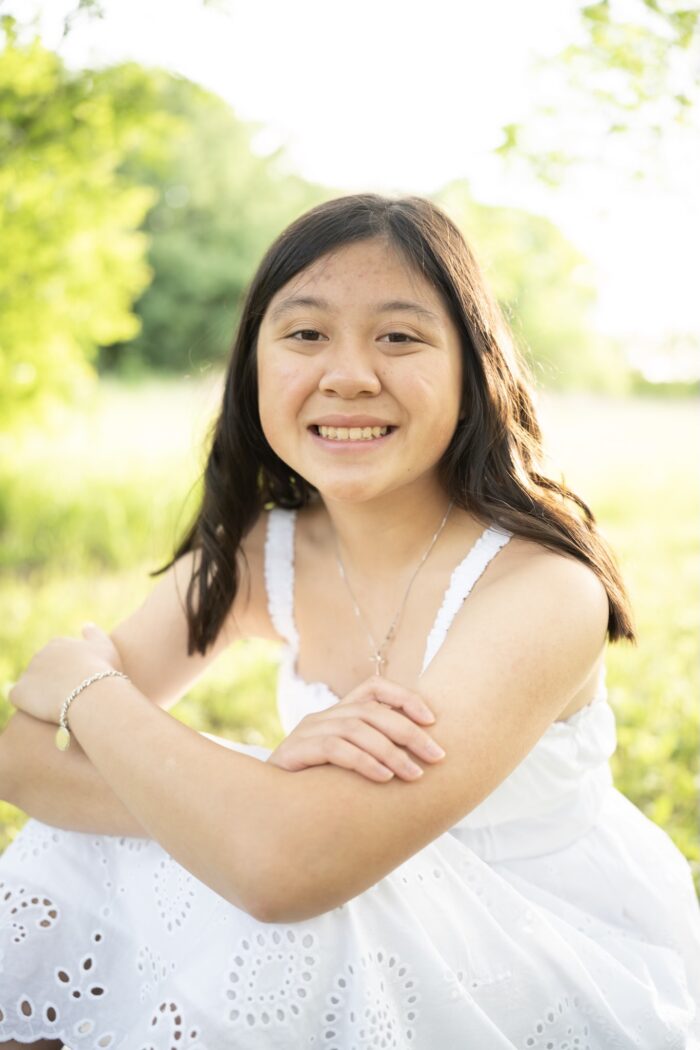 Catherine An Ha sitting in field