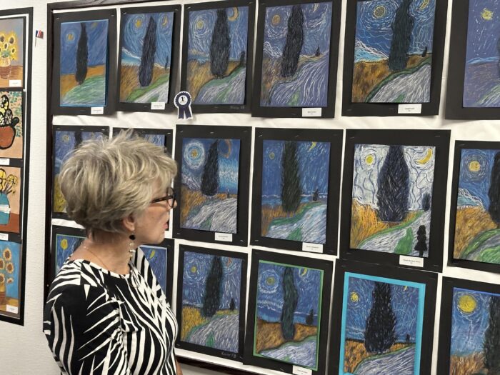 Parent looking at artwork at Art Night