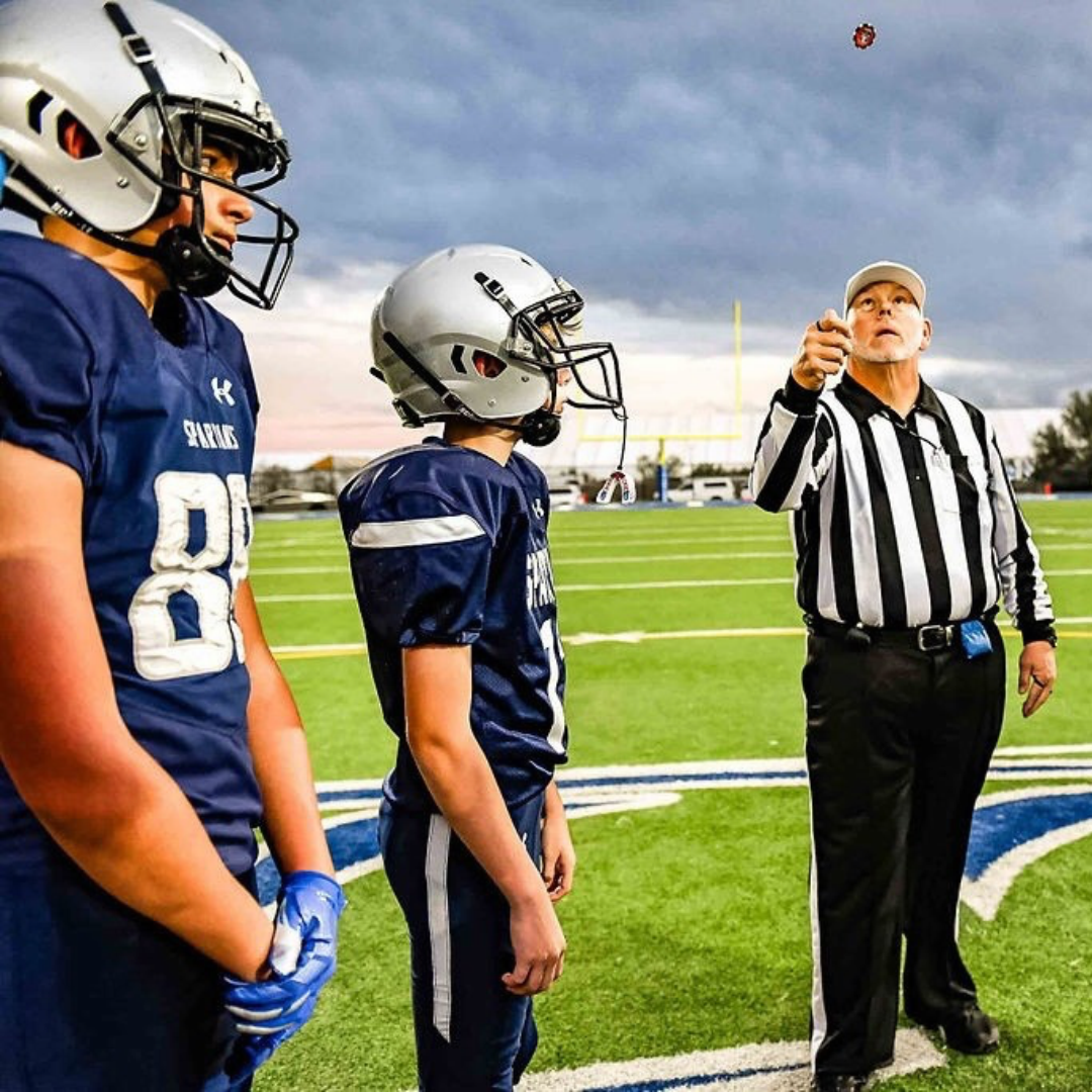 Ref flipping a coin at a football game