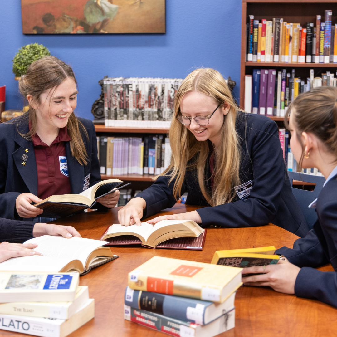 Four high school students sitting at library table